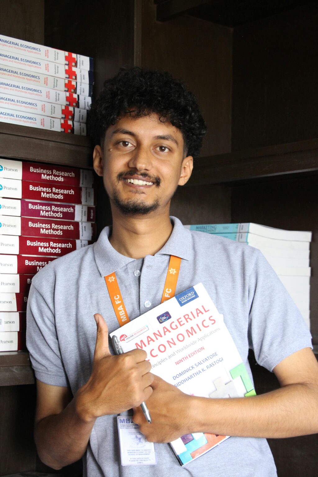 person holding a book named "managerial economics"